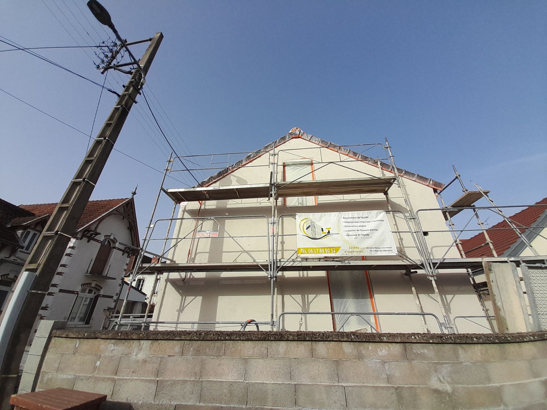 Pignon d'une maison avec des échafaudages pour des travaux de cheminée.