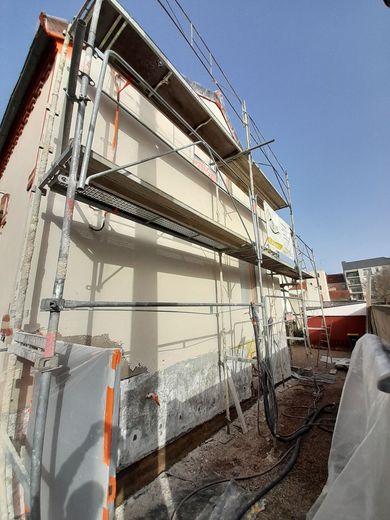 Extérieur d'une maison avec des échafaudages pour rénovation.