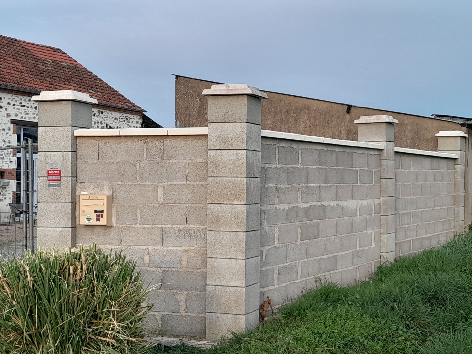 Bâtiment délabré, avec une porte et une fenêtre condamnées, un toit de tuiles et boiseries moussues.