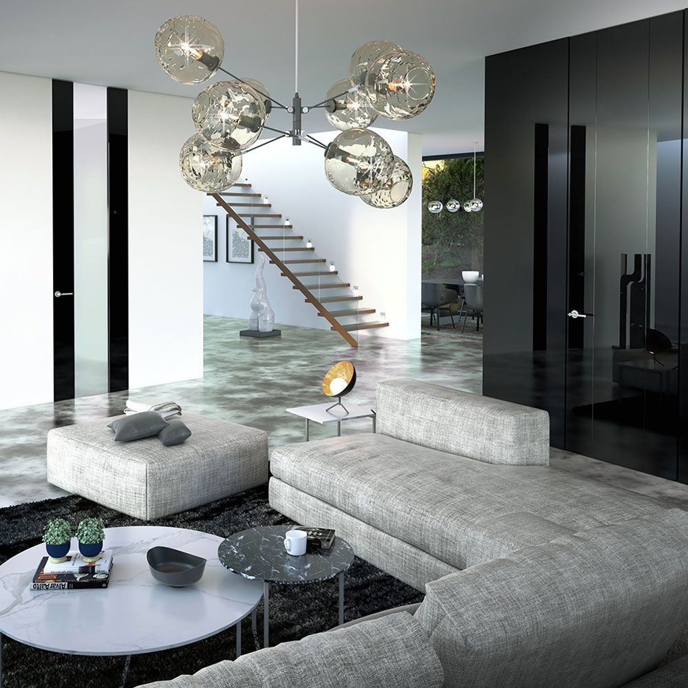 Una sala de estar con un sofá y escaleras al fondo.
