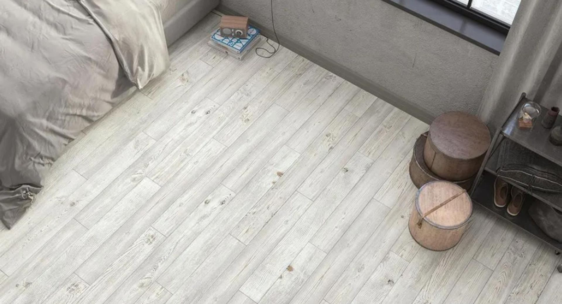 Un dormitorio con suelo de madera blanca y una cama.