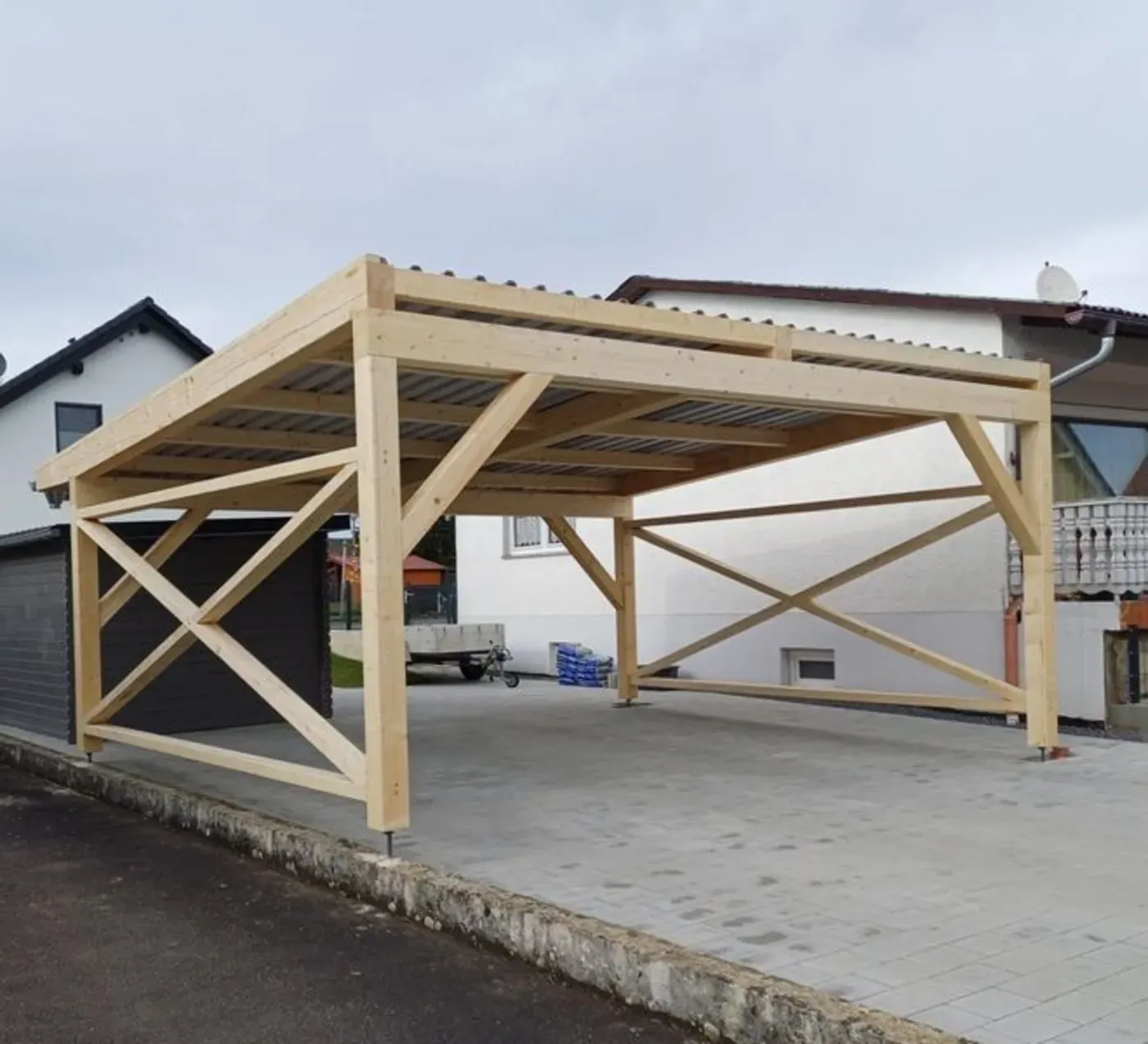 Holzrahmen für einen Carport im Bau neben einem Haus auf einer Einfahrt