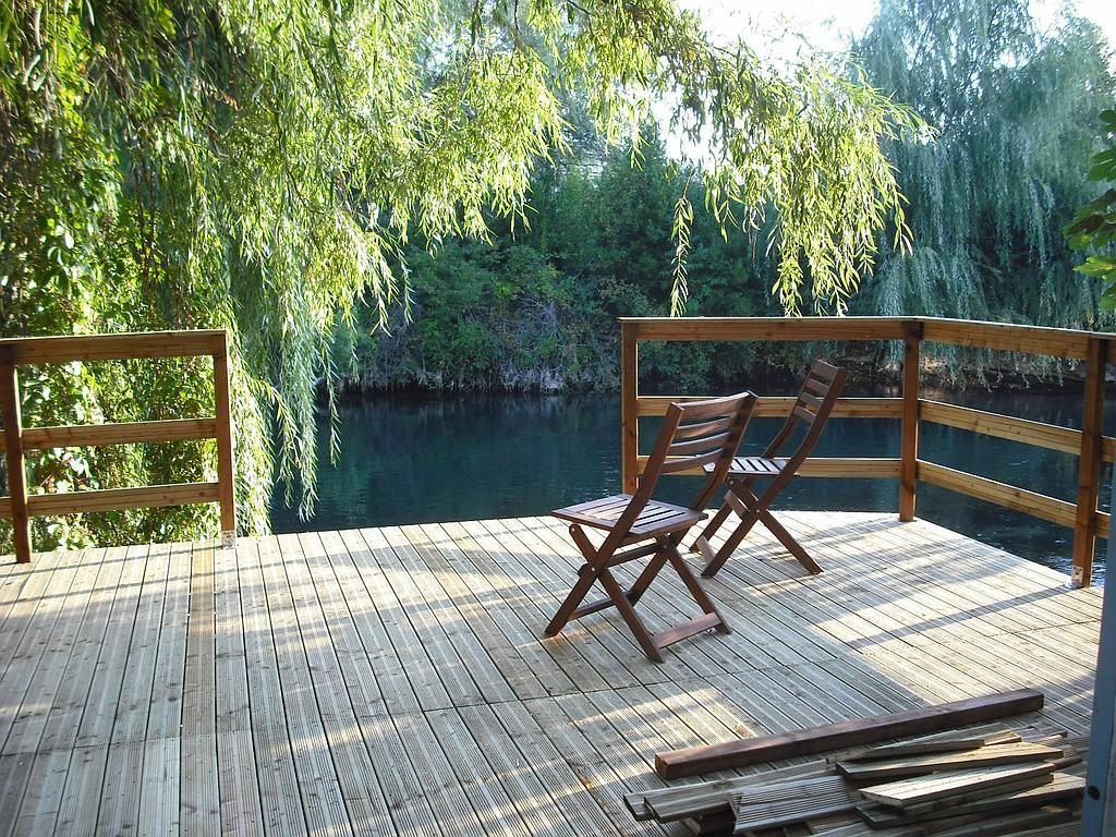 Terrasse en bois avec des chaises en bord de rivière