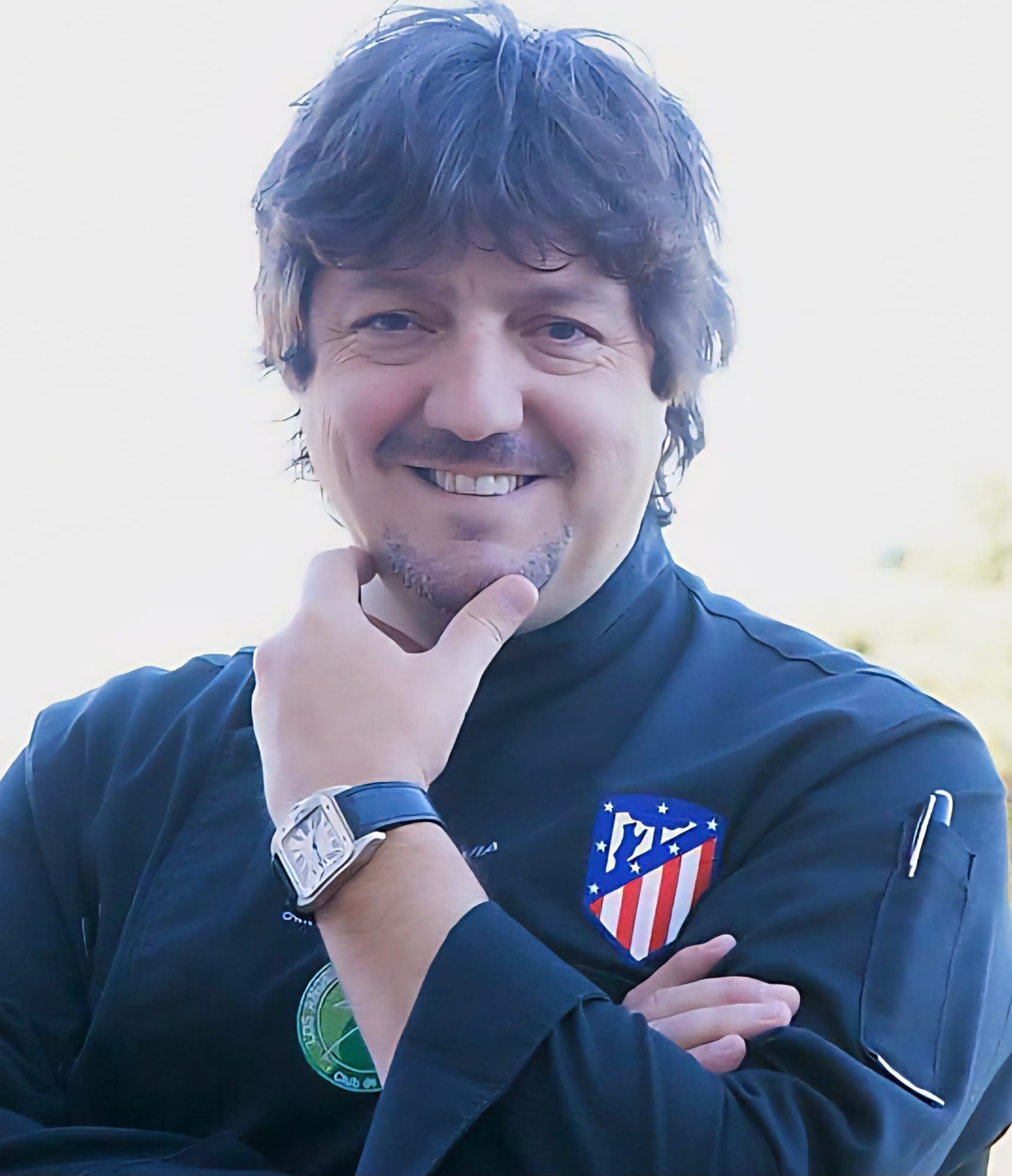 Tomates de variedad antigua en rodajas dispuestos en círculo sobre un plato blanco, coronados con un medallón de queso de cabra dorado.