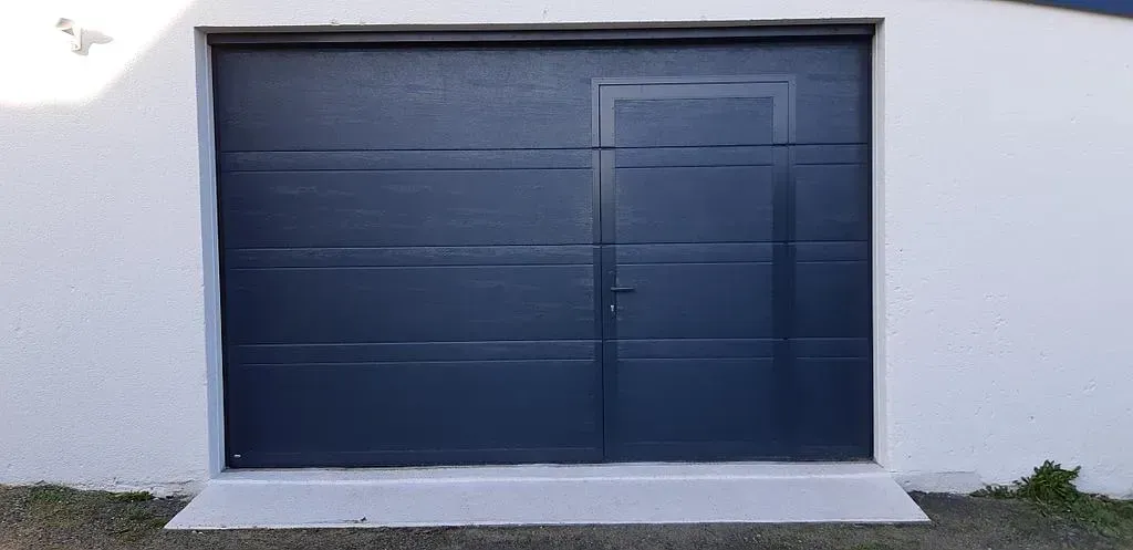Porte de garage sectionnelle gris foncé avec porte piétonne 