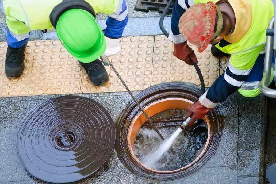 Kanalarbeiter für die Reinigung und Reparatur von Abwasserrohren in der Stadtstraße