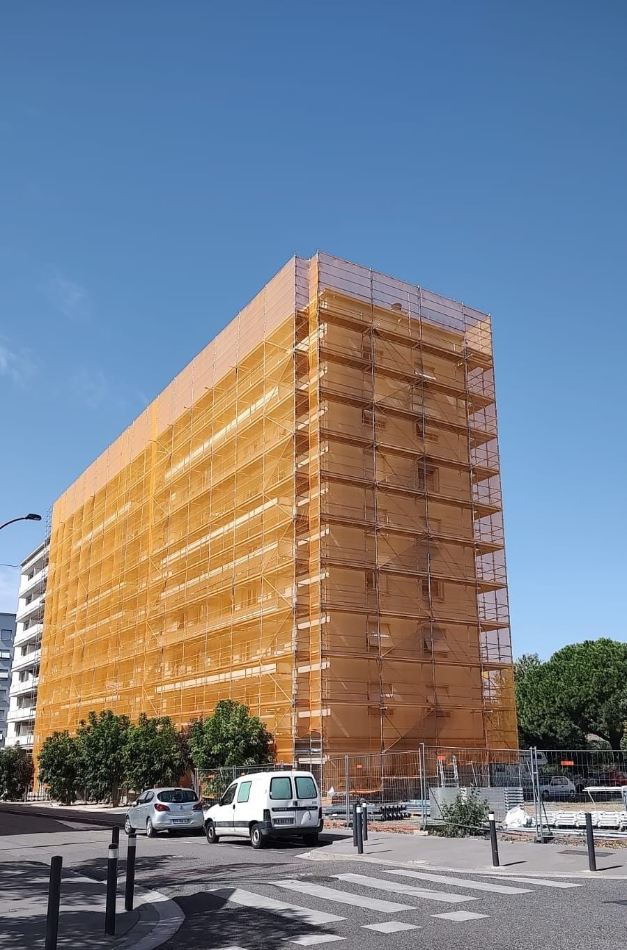 Échafaudage autour d'un immeuble - filet antigravats jaune autour