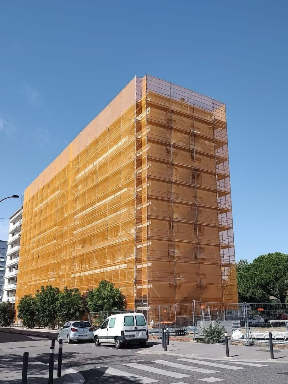 Échafaudage autour d'un immeuble - filet anti-gravâts jaune autour