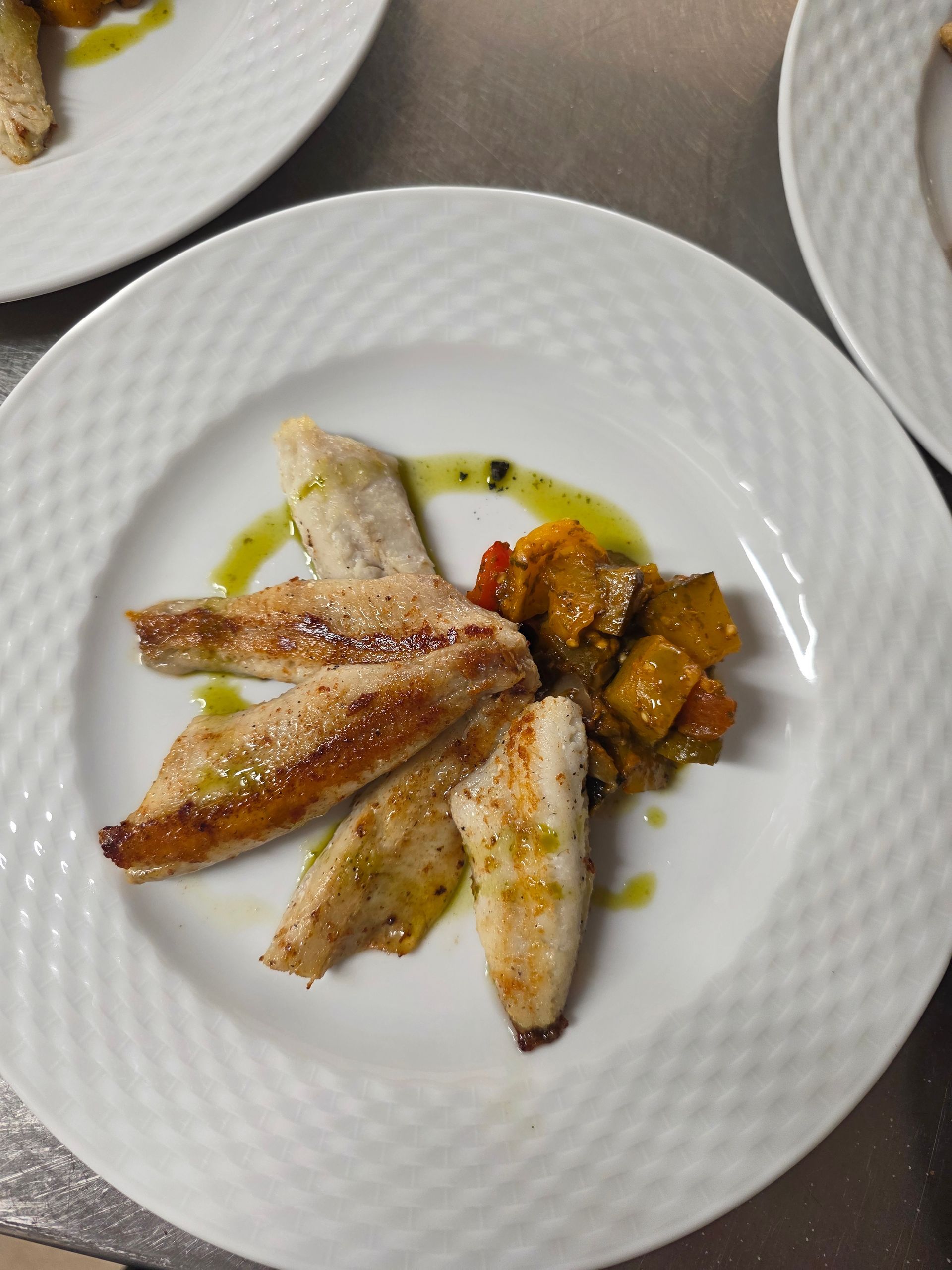 Filets de poulet nappés de sauce, servis sur une assiette blanche.
