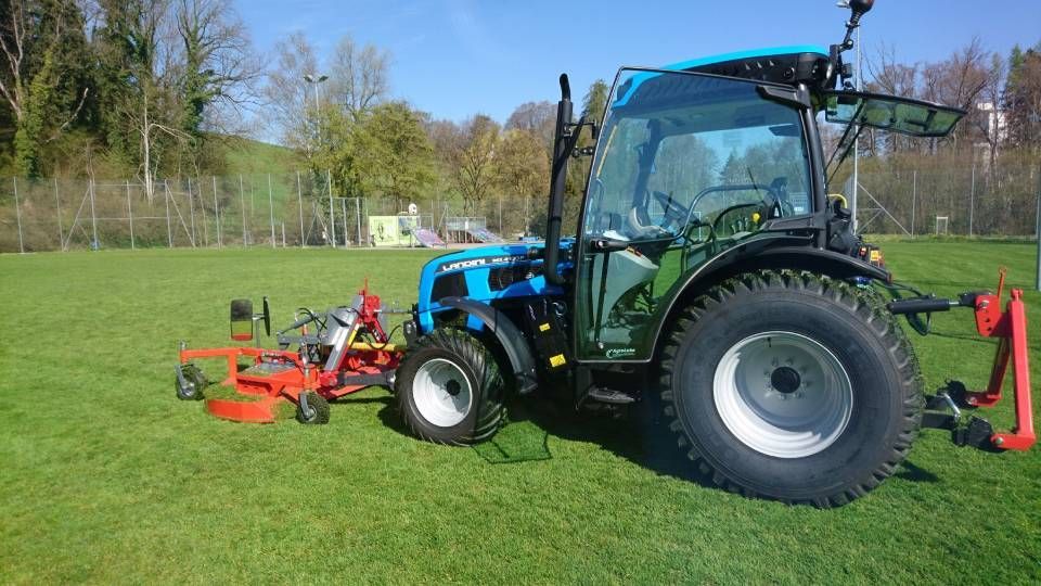Ein blauer Traktor steht auf einer Wiese