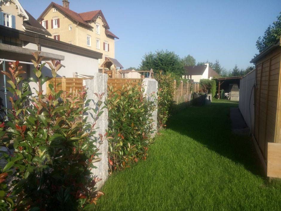Ein Hinterhof mit einem Zaun und einem Haus im Hintergrund