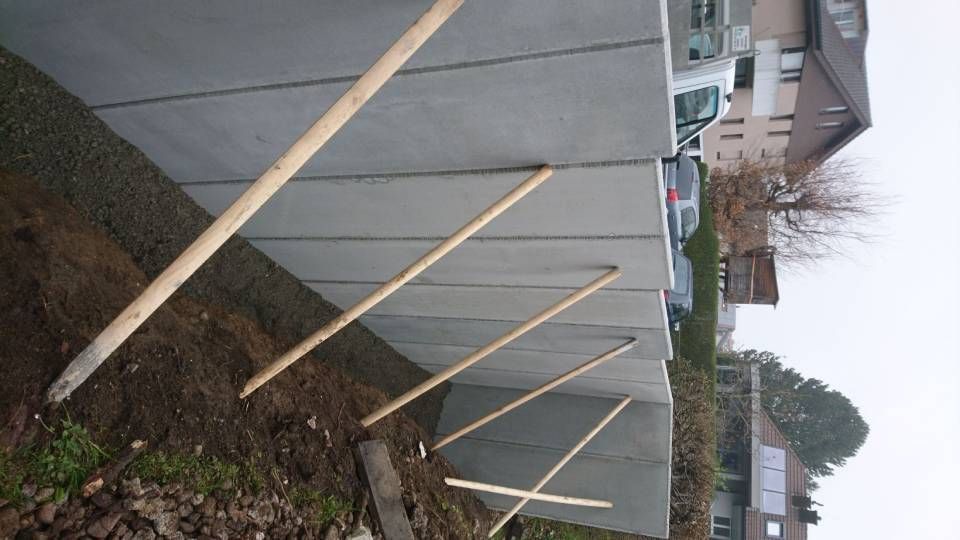 Eine Betonmauer mit daran befestigten Holzpfosten. Foto von der Sonderegger Gartenbau GmbH