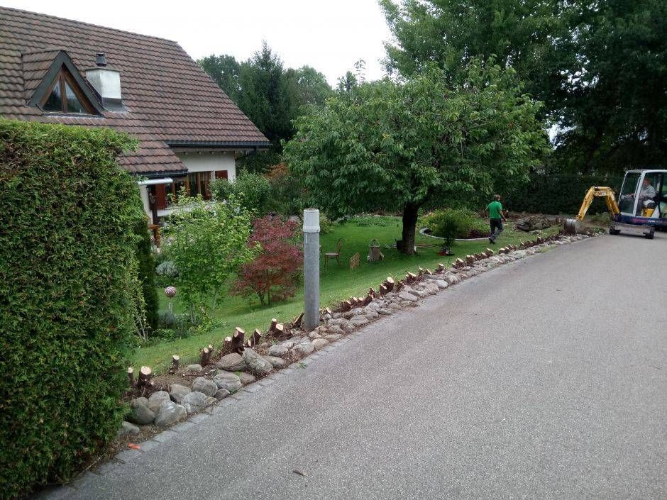 Ein gemauerter Gehweg mit einem Fahrradschild im Hintergrund. Foto von der Sonderegger Gartenbau GmbH
