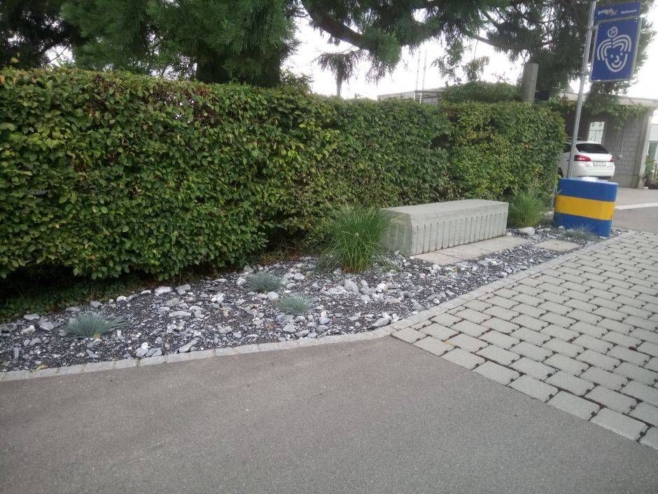 Ein gemauerter Gehweg mit einem Fahrradschild im Hintergrund