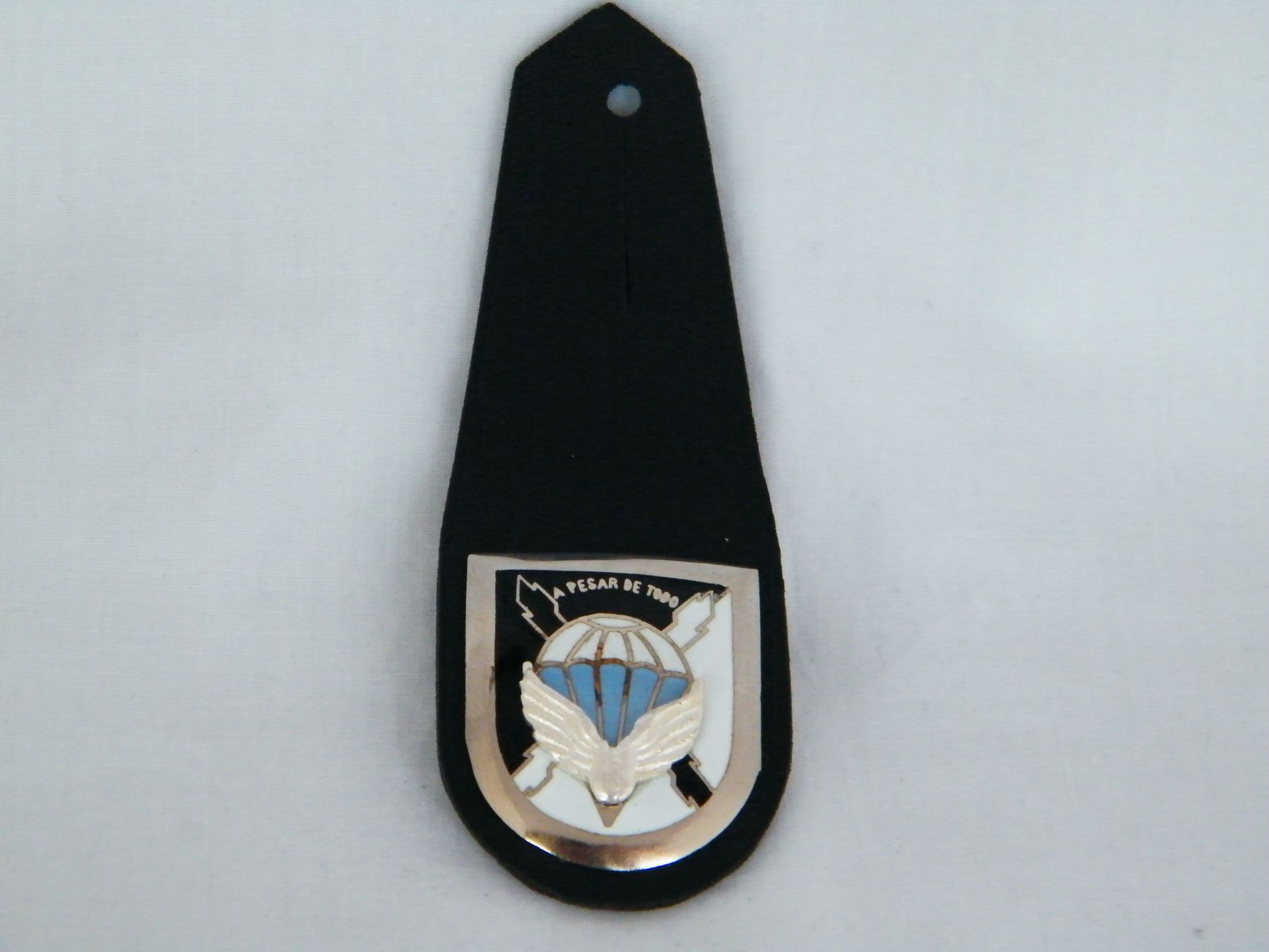 Una insignia negra con un paracaídas.