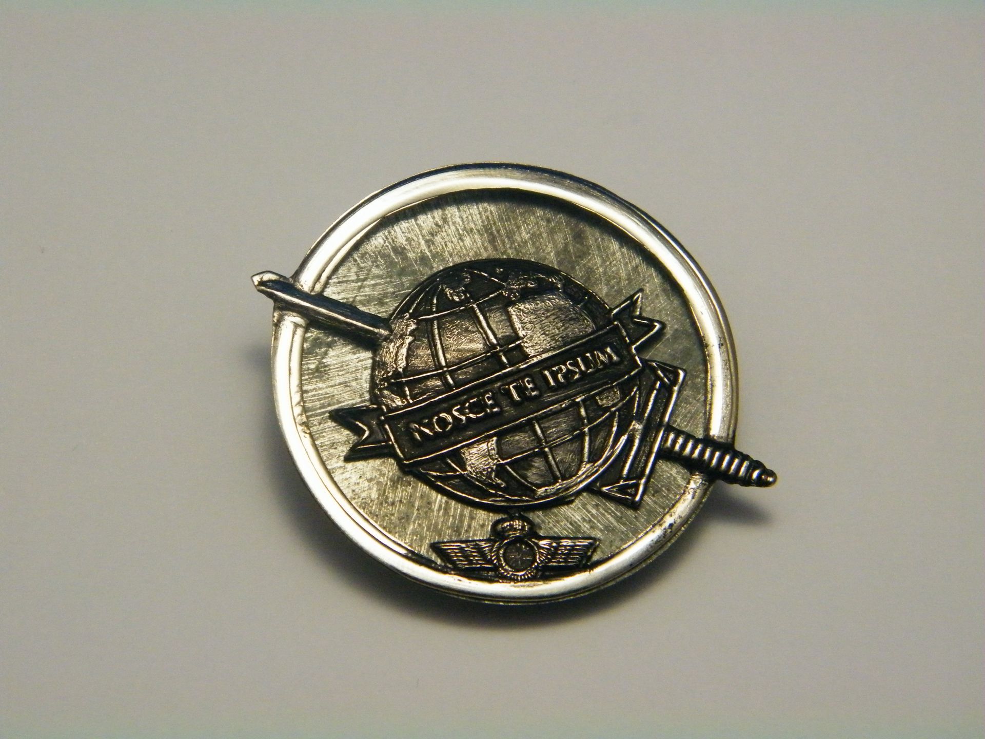 Una moneda con un globo terráqueo y dos espadas.