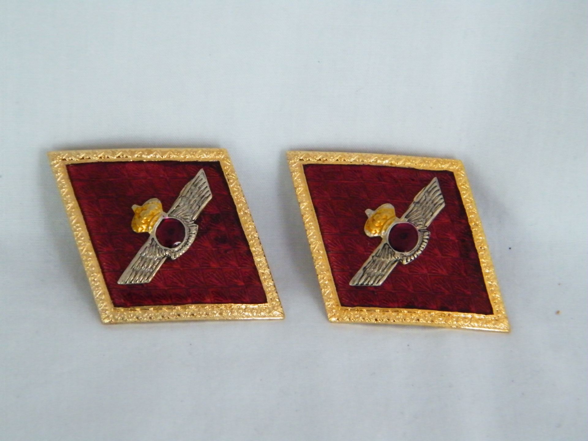 Un par de gemelos rojos y dorados con un pájaro en ellos.