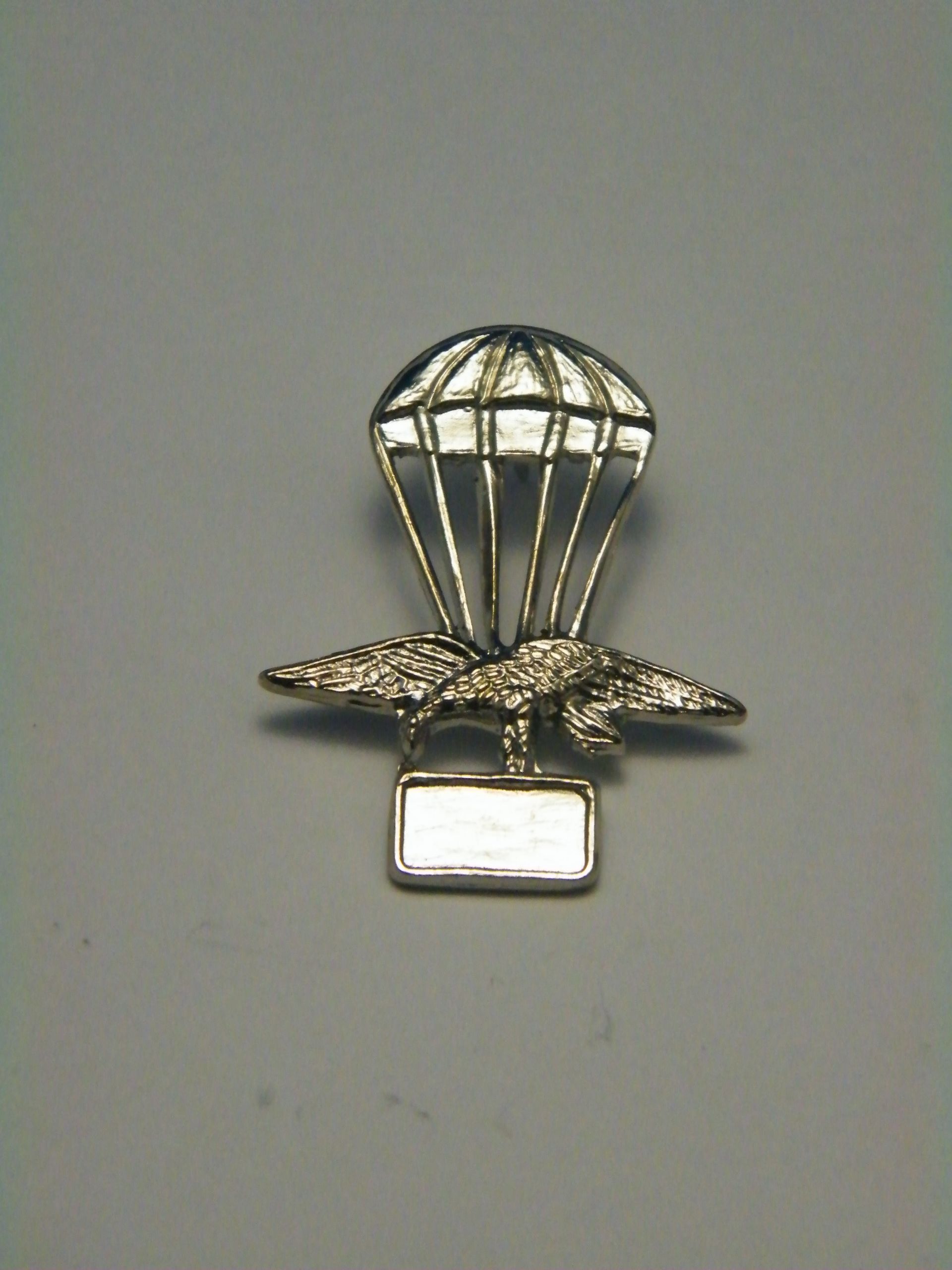 Un broche con un paracaídas y un pájaro.