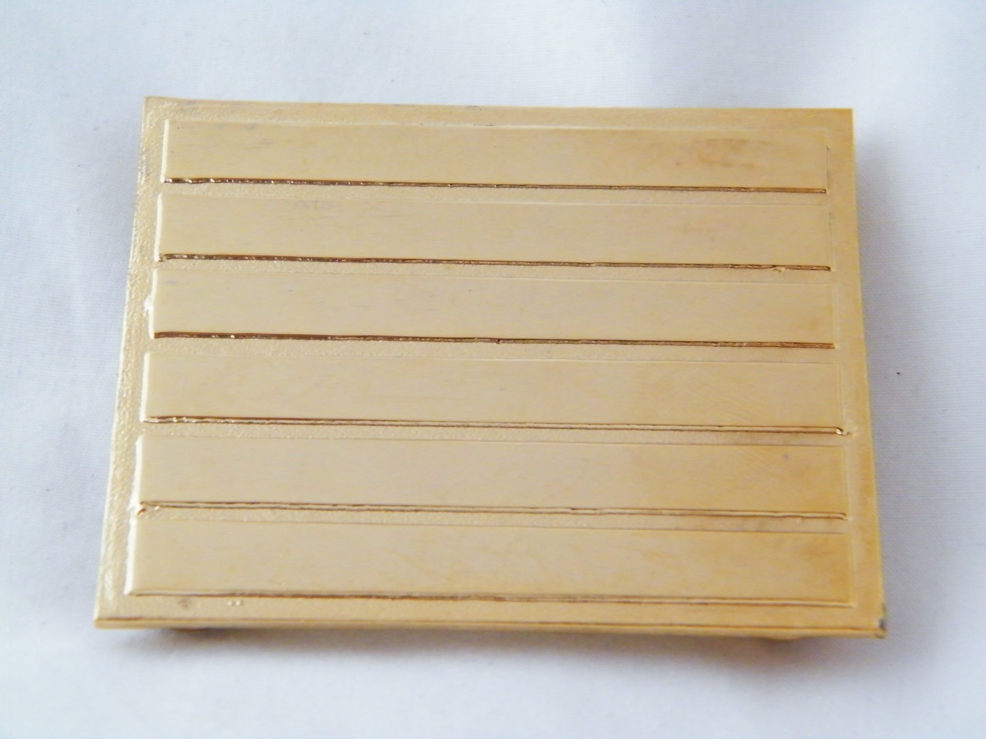 Un trozo cuadrado de madera con algunas líneas.