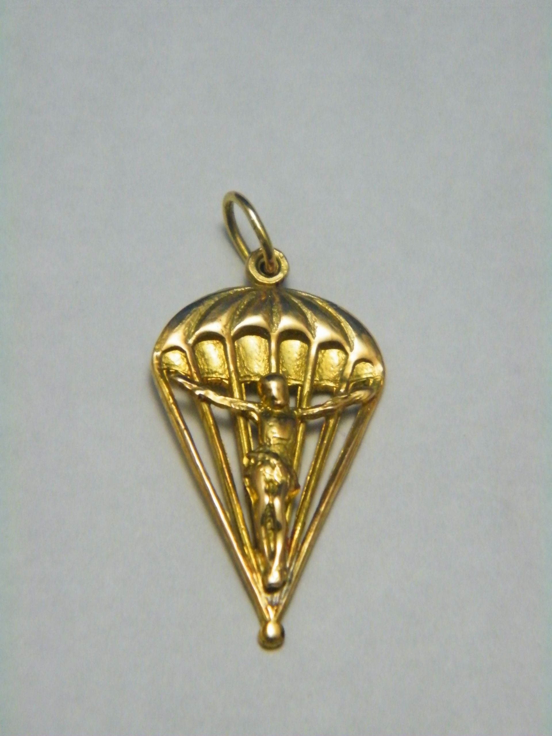 Un colgante de oro con un paracaídas.