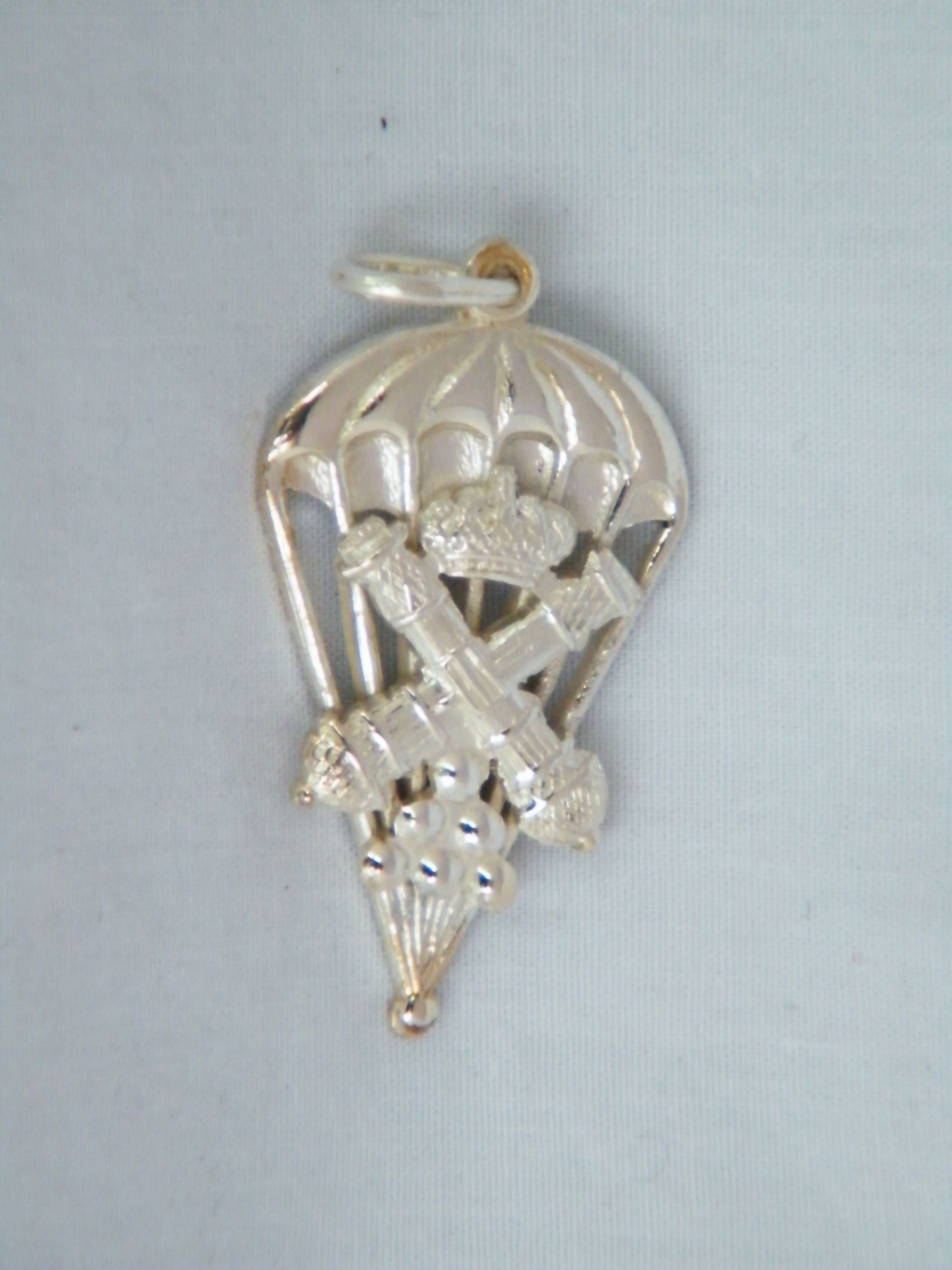 Un colgante de plata con un paracaídas.