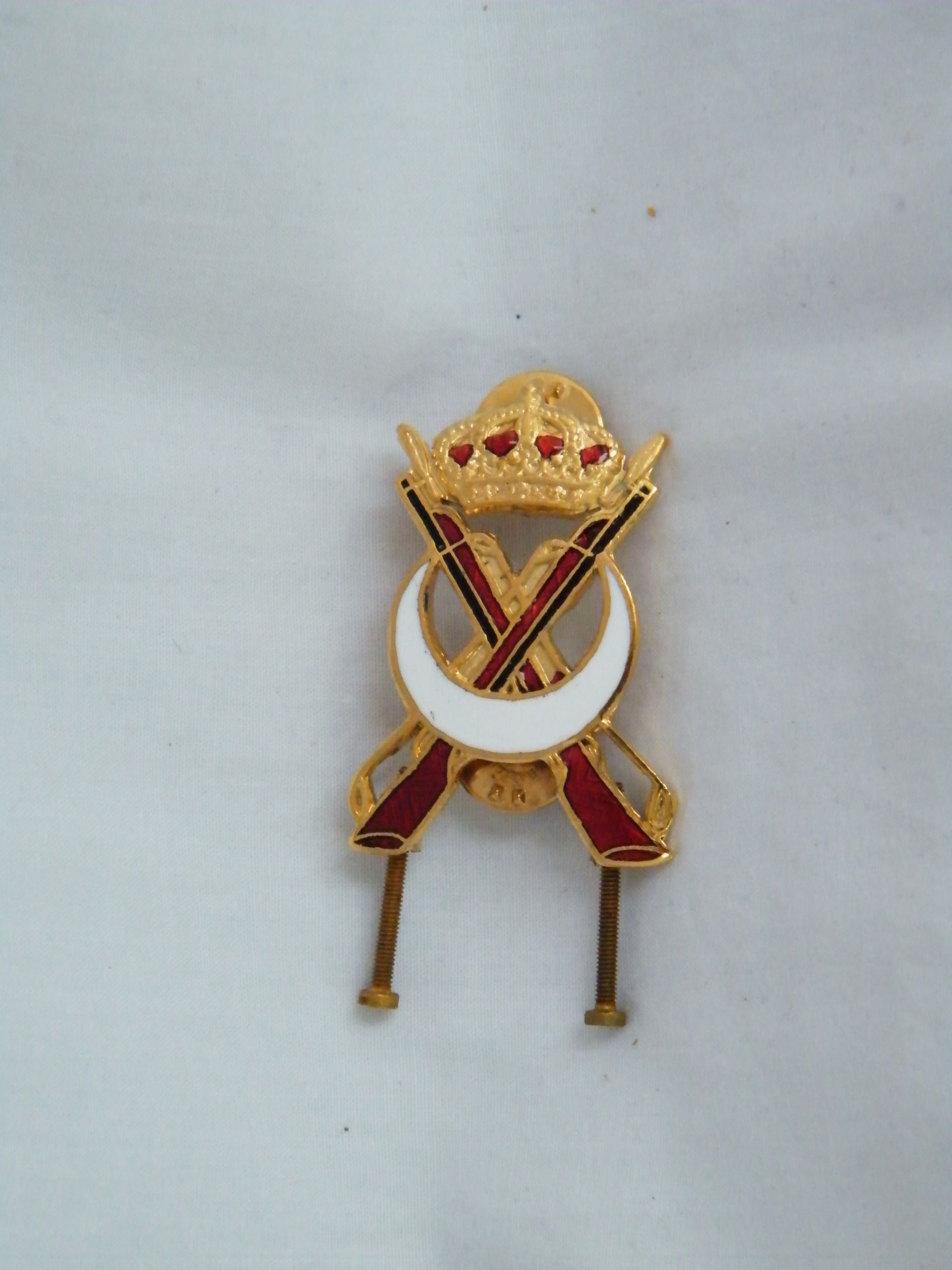 Un broche de oro con una luna creciente y espadas cruzadas.