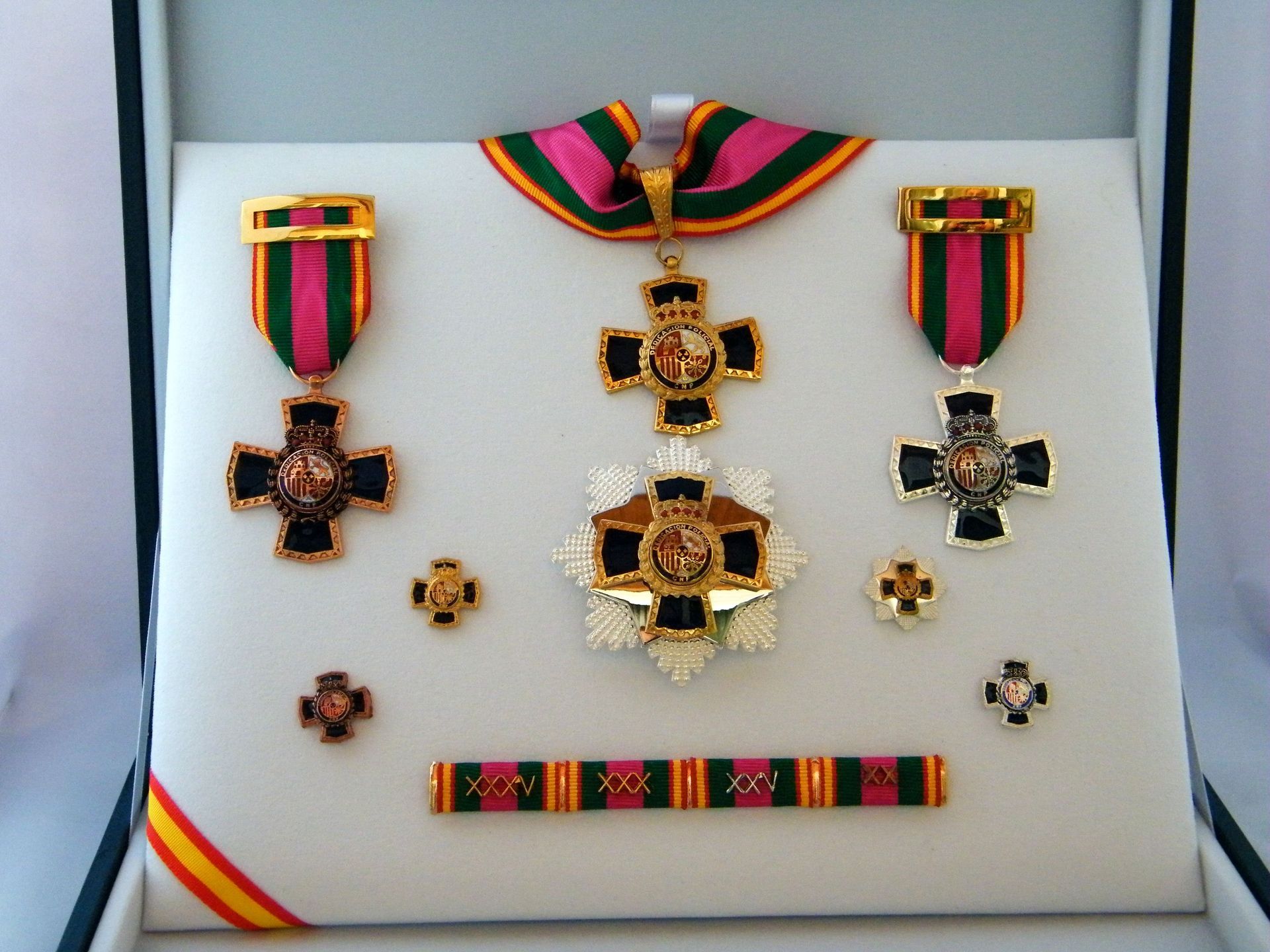 Un conjunto de medallas en una caja con una cinta roja y verde.