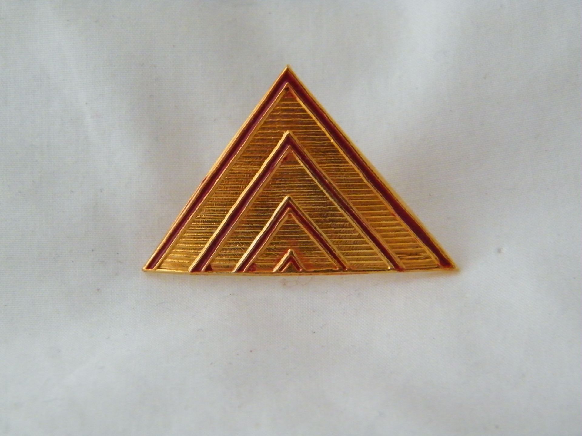 Un triángulo dorado con la letra a en él.