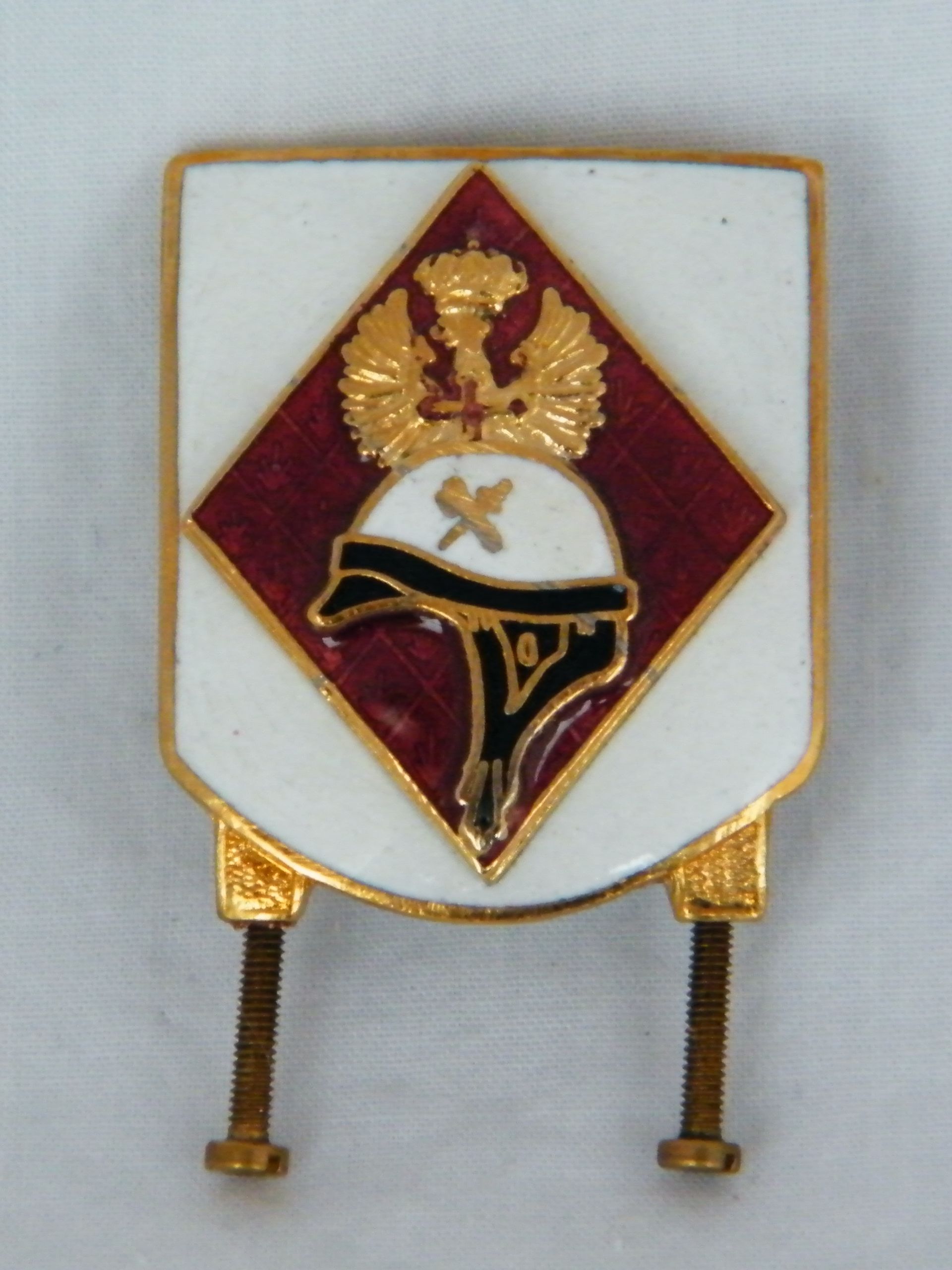 Una insignia con un casco y una cruz.