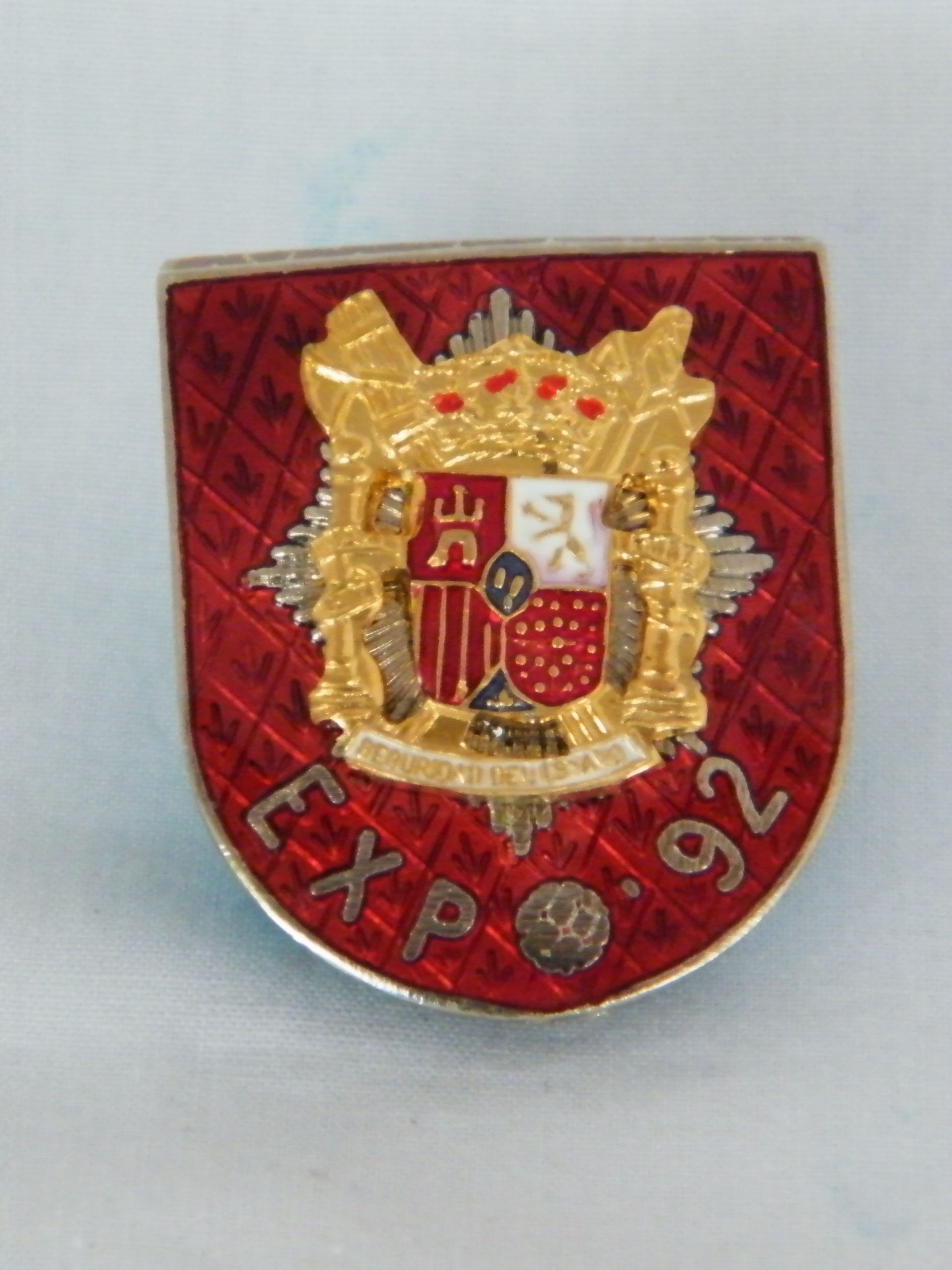 Un pin rojo y dorado que dice Expo 92.