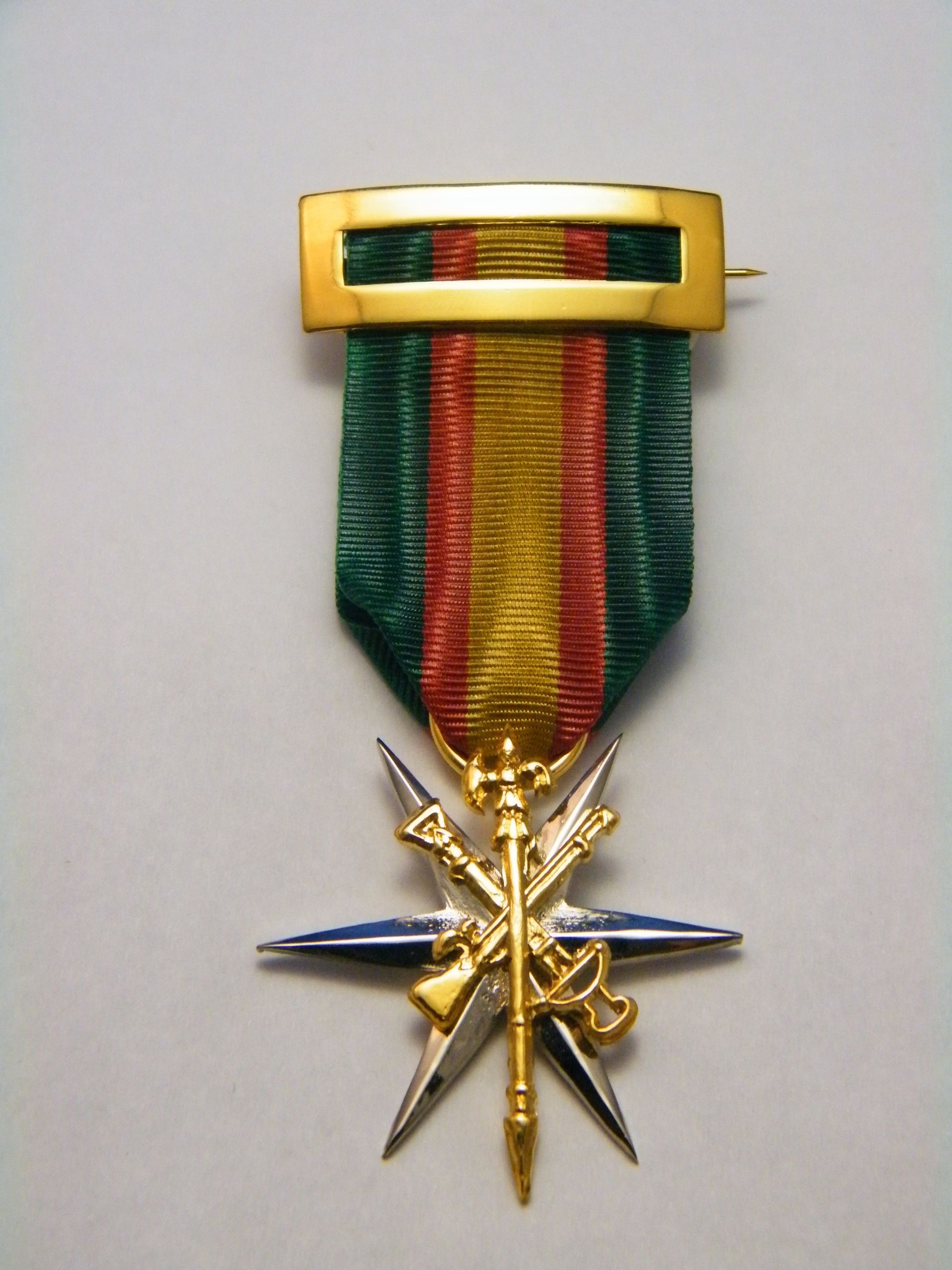 Una medalla de oro con una cinta verde, roja y amarilla