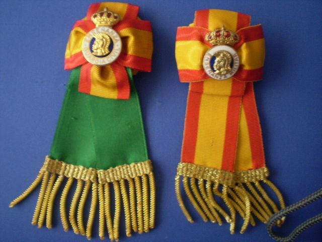 Dos cintas con flecos y una corona sobre ellas