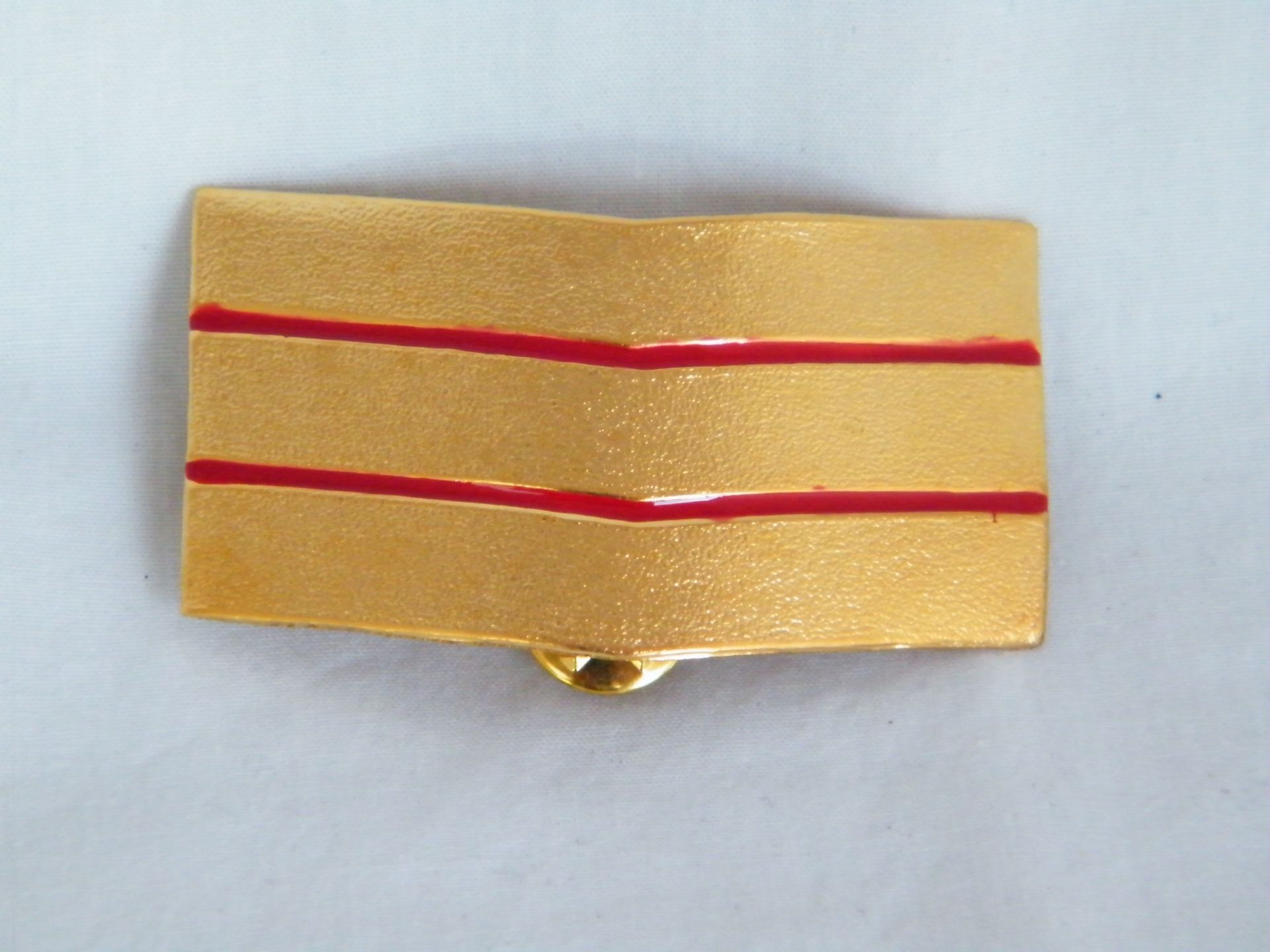 Una placa de oro con rayas rojas.
