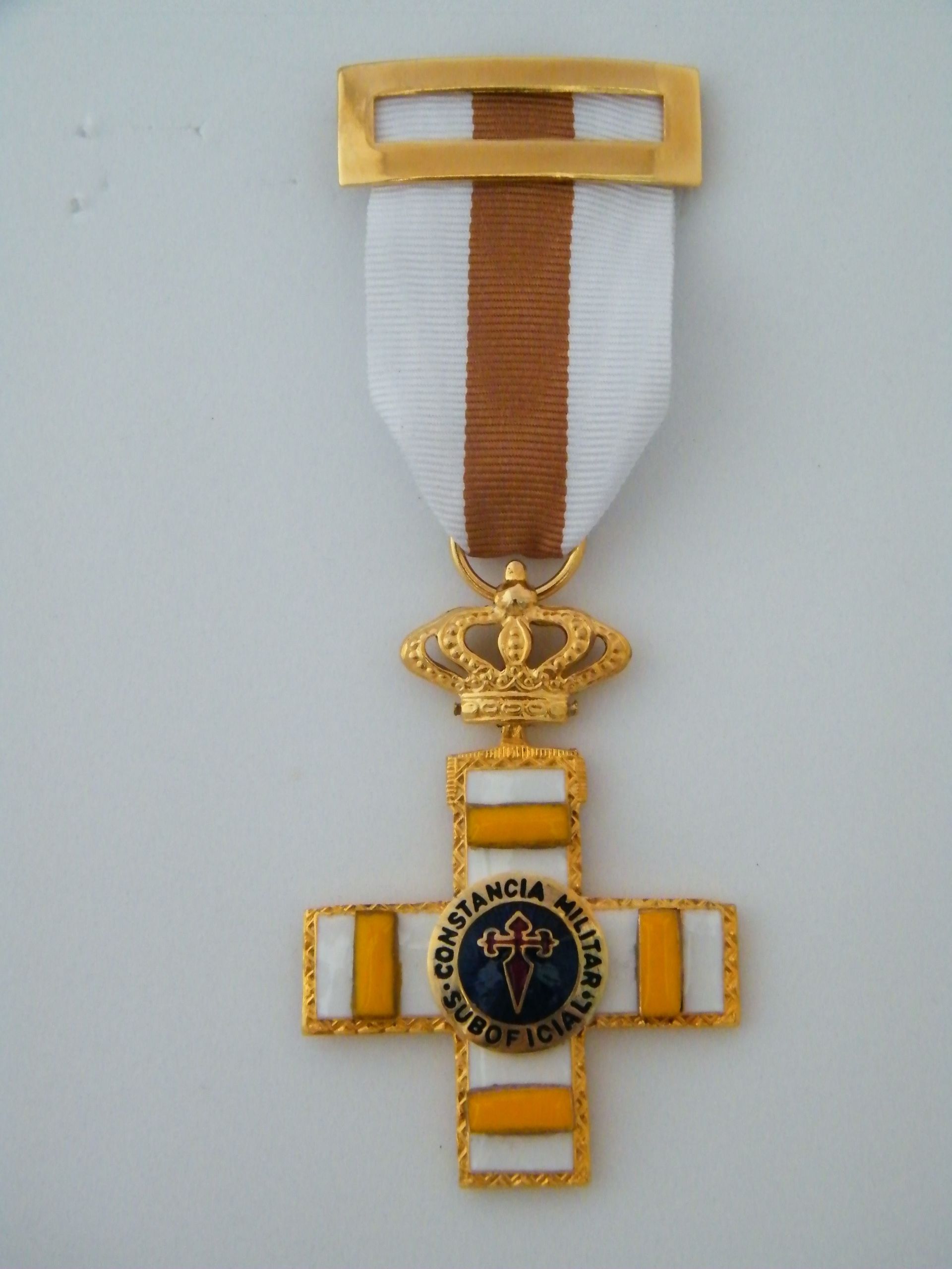 Una medalla de oro y blanco con la palabra constancia en ella