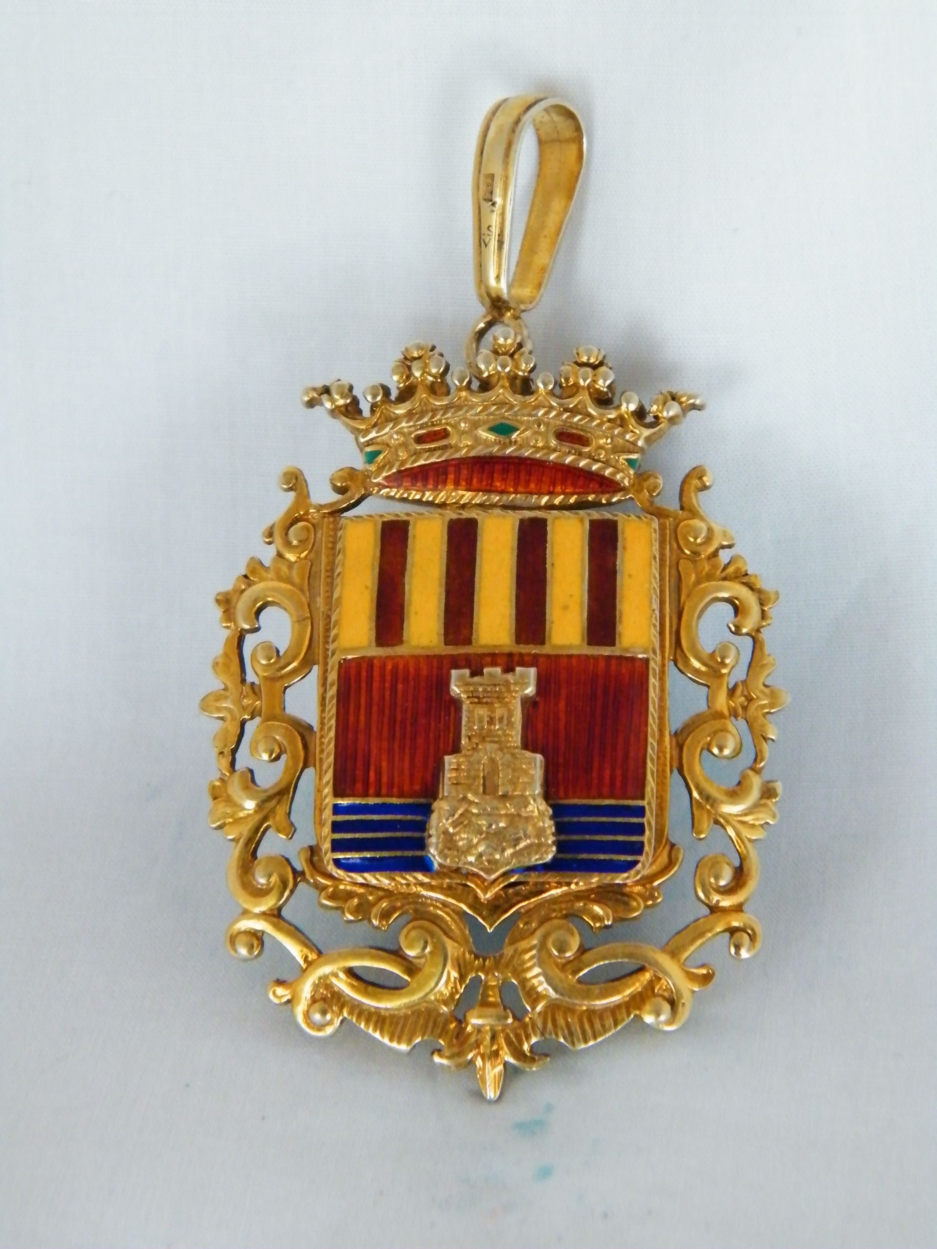 Un colgante de oro con un escudo de armas.