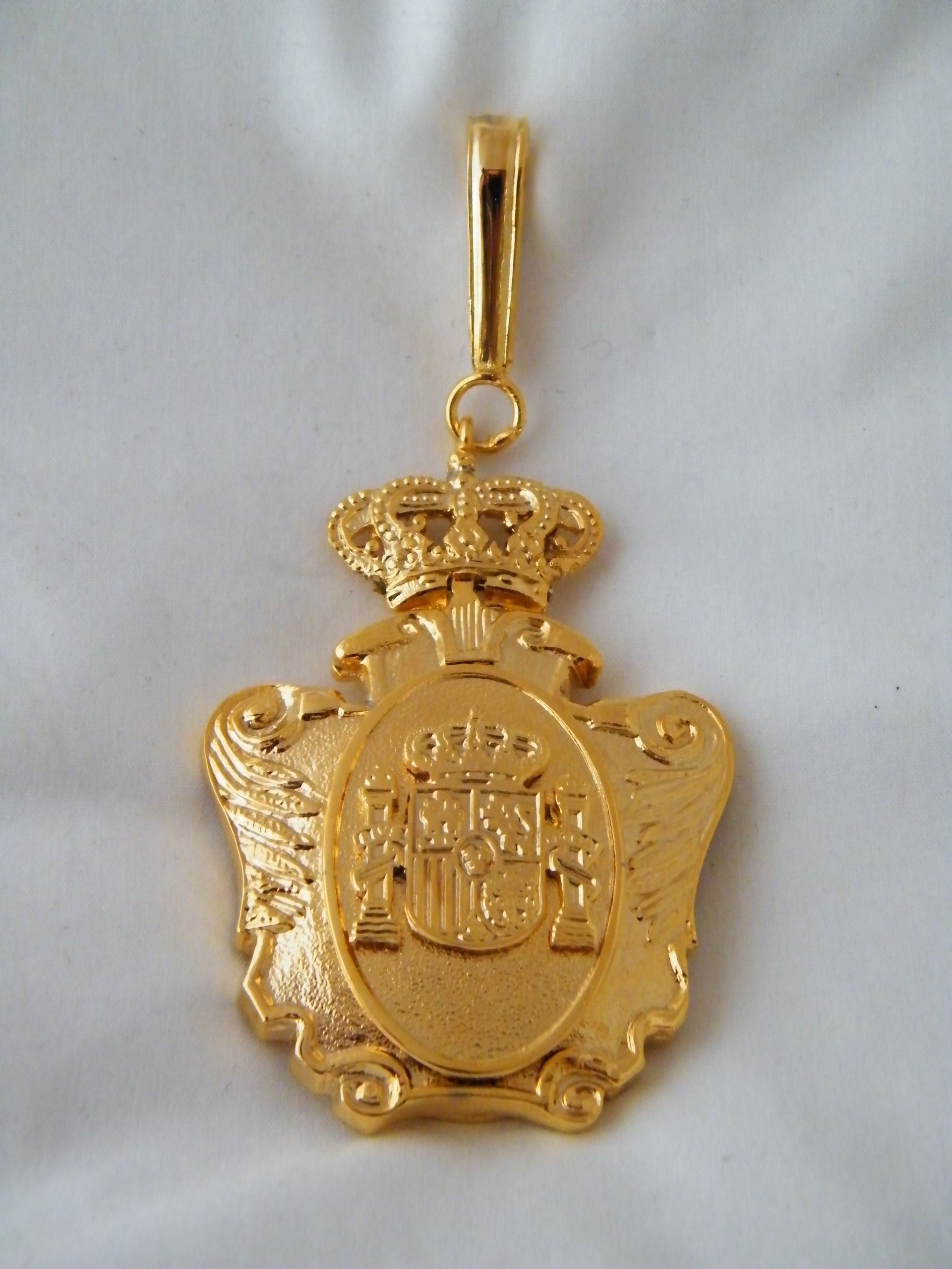 Un colgante de oro con un escudo de armas.