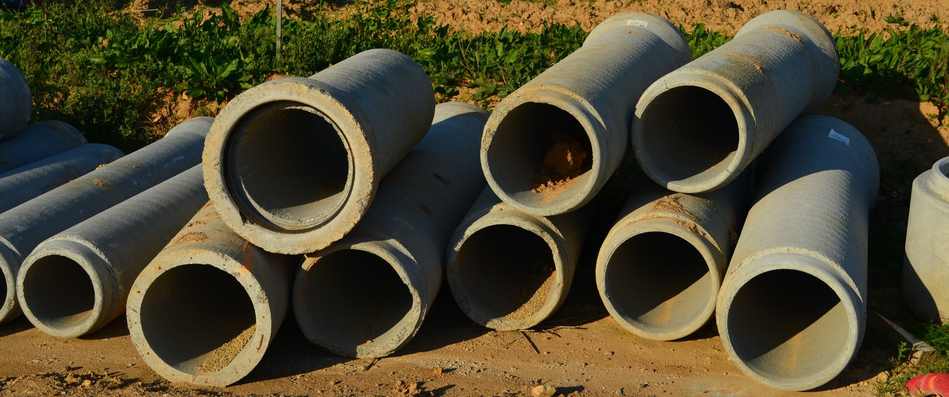 Tuyaux en béton empilés à l'extérieur.