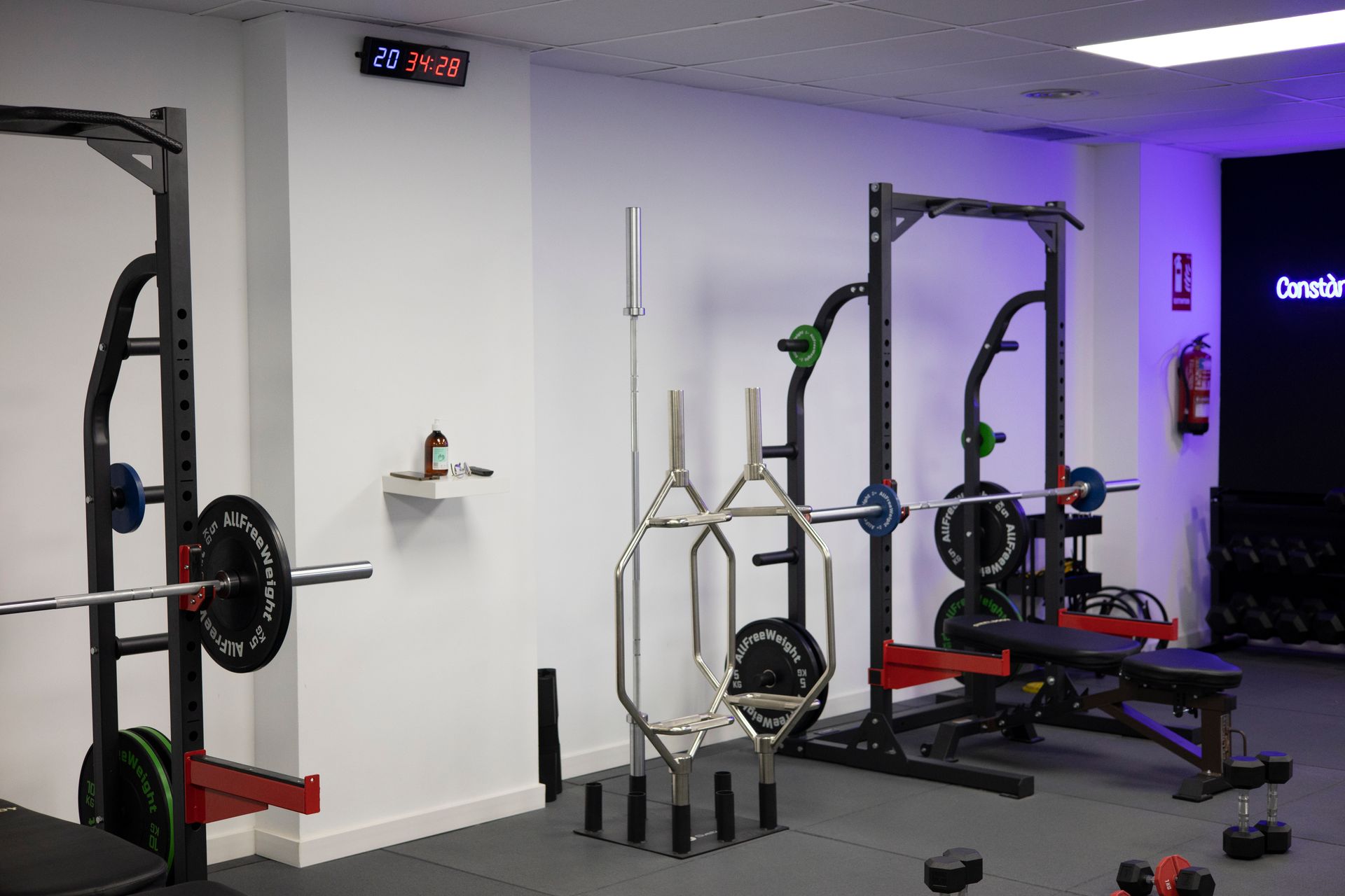 Un gimnasio con mucho equipo de ejercicio y un extintor de incendios.