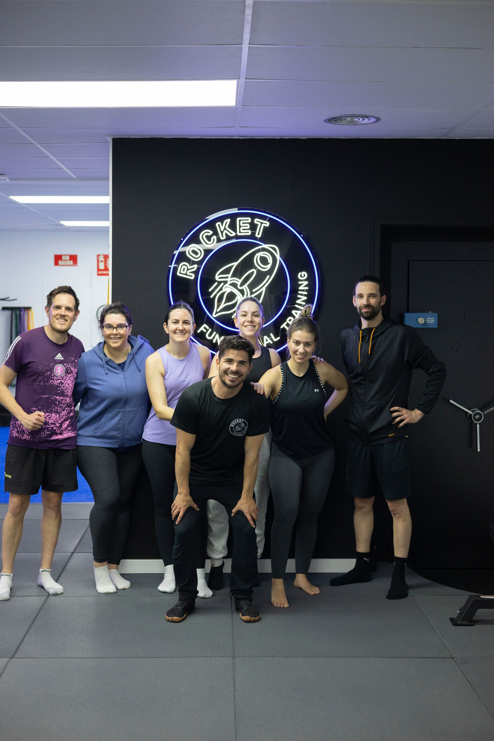 Un grupo de personas posa para una fotografía en un gimnasio.