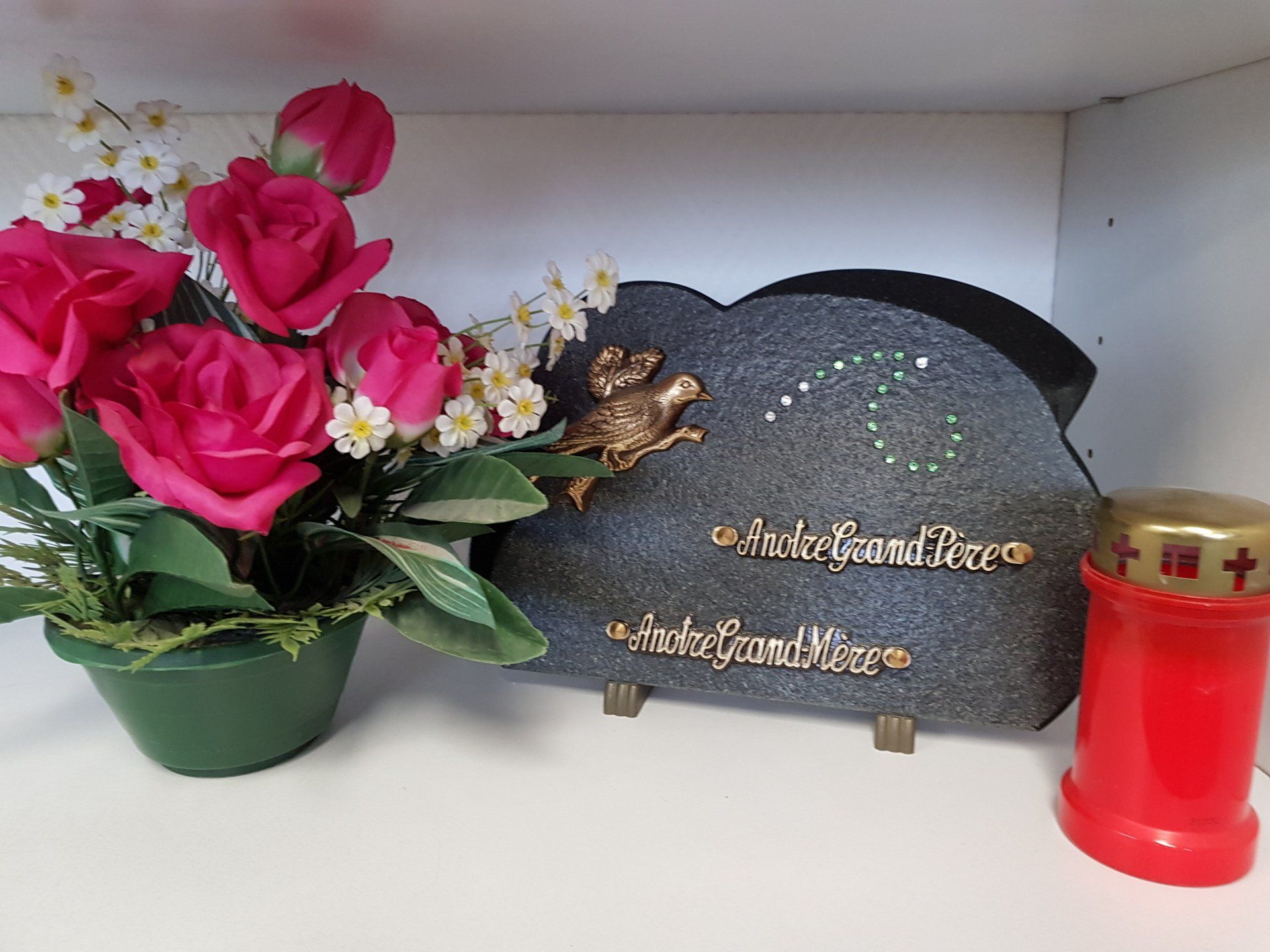 Assortiment de produits : fleurs artificielles, plaque et bougie