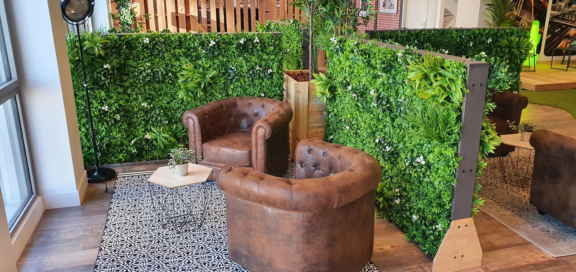 Deux fauteuils devant un mur végétal