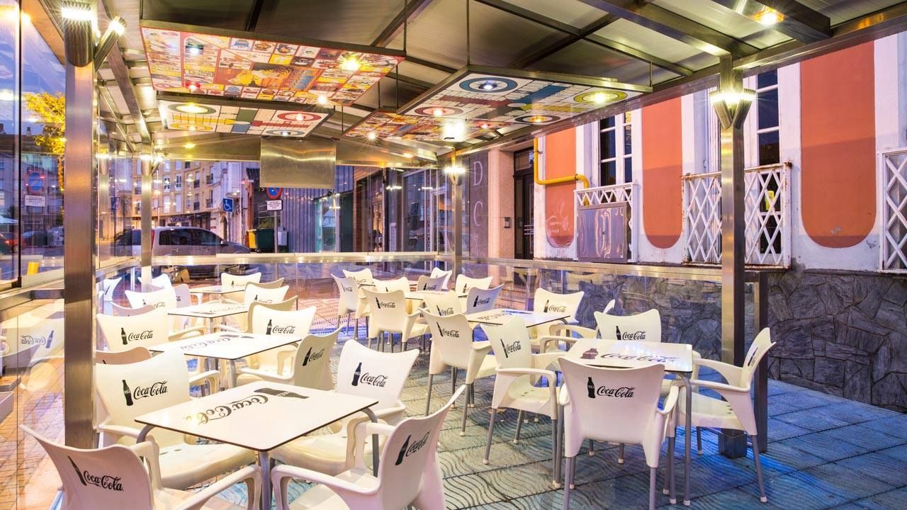 Un restaurante con mesas y sillas frente a un edificio.