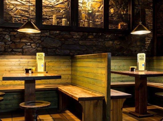 Un restaurante con mesas y bancos y un cartel que dice 'a' en él