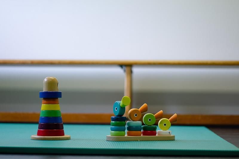 Ein Stapel Ringe und eine Pyramide liegen auf einer grünen Matte.