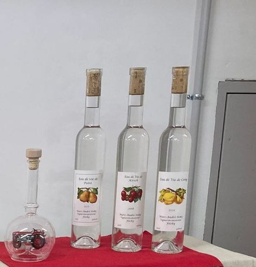 Trois bouteilles d'alcool sont alignées sur une table