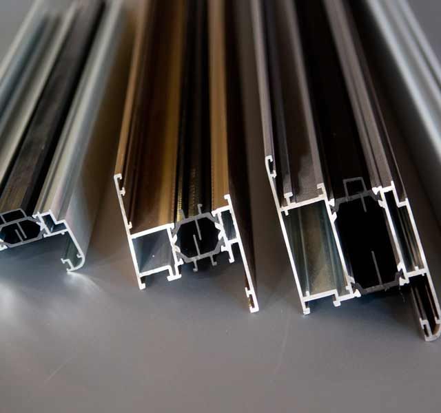 Un grupo de perfiles de aluminio están colocados uno encima del otro sobre una mesa.