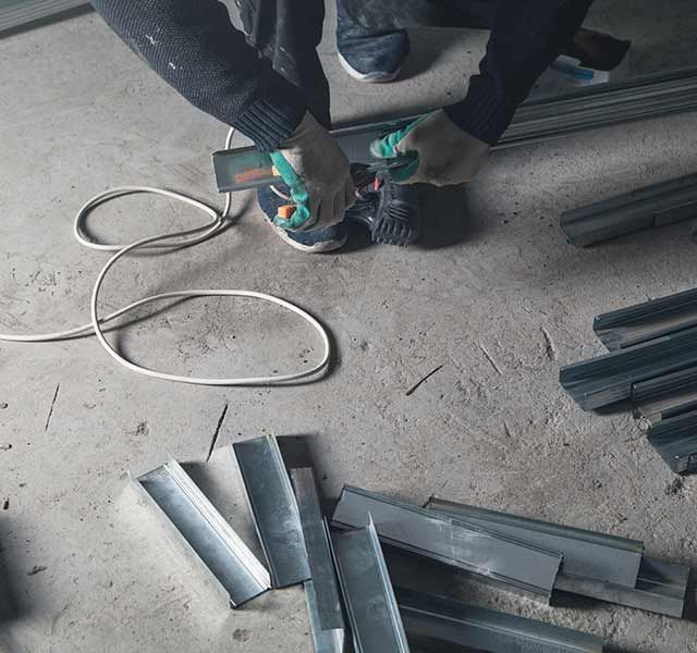 Una persona está trabajando en un trozo de metal en el suelo.