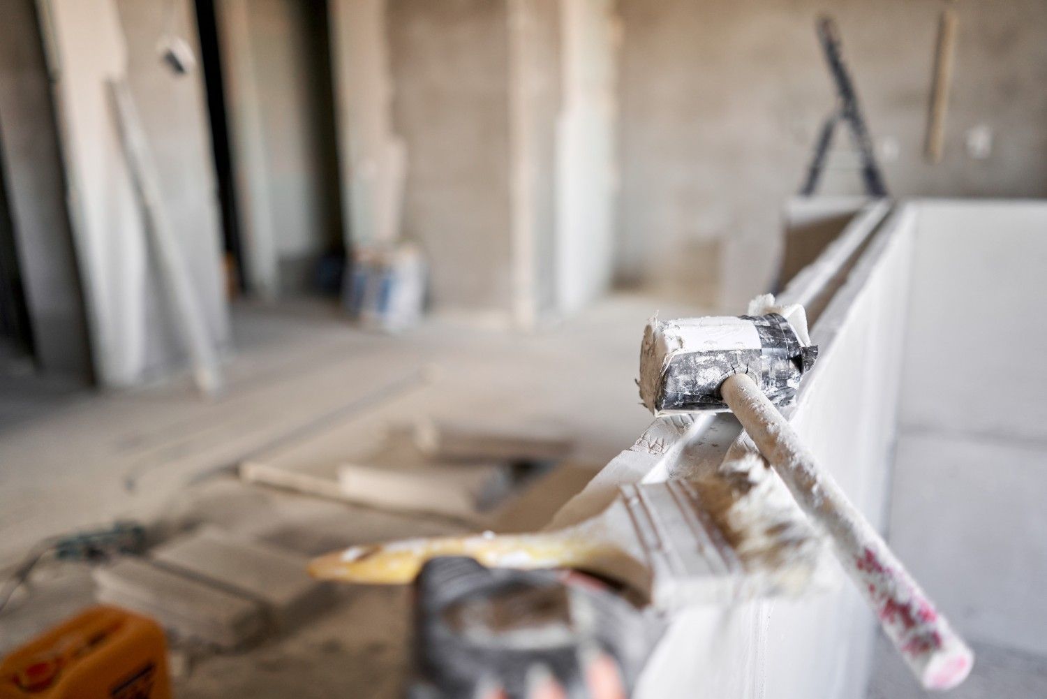 Martillo y otras herramientas en la repisa de un espacio de construcción sin terminar.