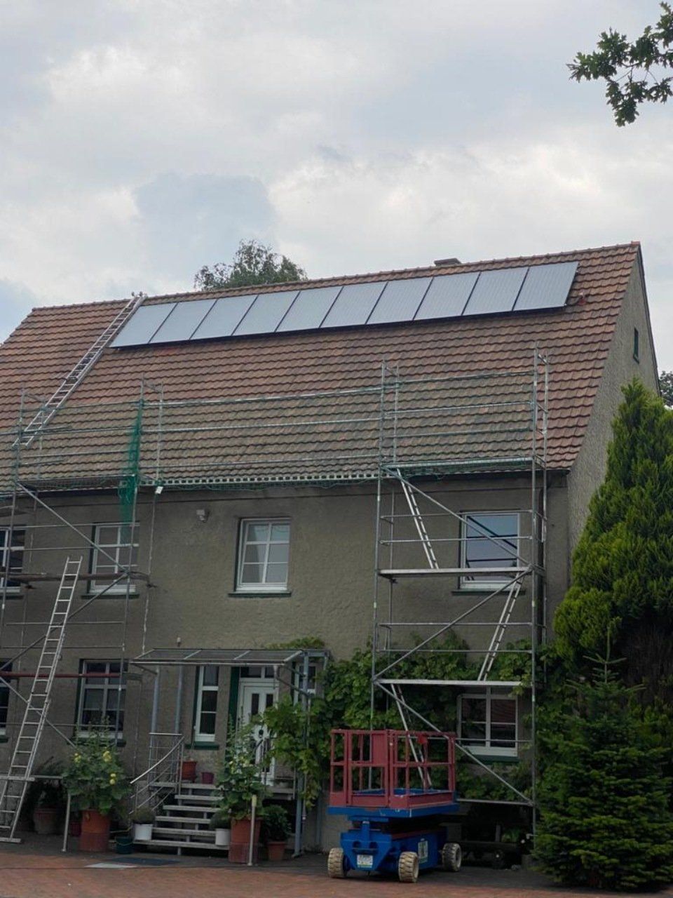 Lars Vornheder GmbH Heizung Sanitär Gerüst an einem Haus mit Solarplatten auf dem Dach