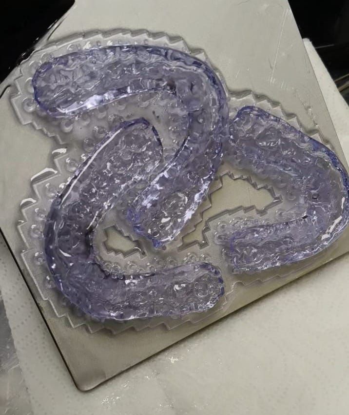 Una sustancia gelatinosa, transparente y de color azul, con forma de cadena, sobre una superficie gris.